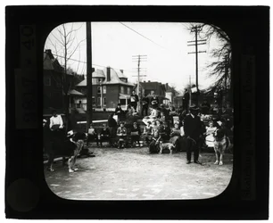 Horizontal, black and white photo of students drawing dogs in an outdoor classroom setting